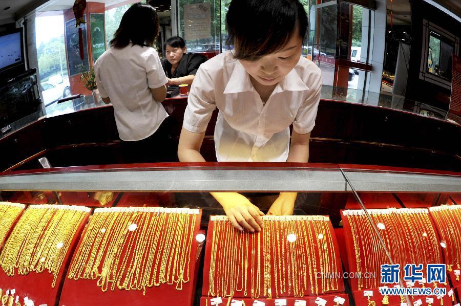 9月26日，浙江義烏一金店工作人員在整理上柜銷(xiāo)售的黃金飾品。隨著國(guó)際黃金市場(chǎng)風(fēng)云突變，國(guó)內(nèi)金價(jià)26日繼續(xù)大跌。與此同時(shí)，曾經(jīng)高高在上的鉑金價(jià)格也大幅下調(diào)，出現(xiàn)了黃金價(jià)格全面高于鉑金價(jià)格的罕見(jiàn)倒掛現(xiàn)象。26日，上海黃金交易所黃金Au99.95合約收盤(pán)價(jià)為每克327.95元，而鉑金Pt99.95合約收盤(pán)價(jià)僅為每克326.08元。