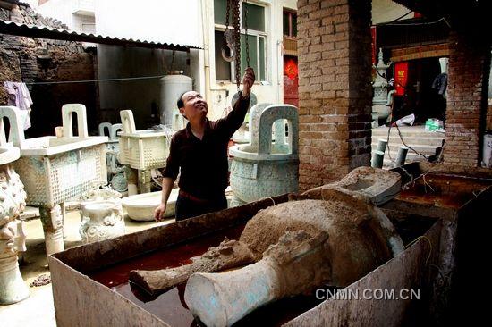 河南省洛陽(yáng)煙澗村的青銅器高仿作坊中，一件半成品被浸泡進(jìn)電解水中，進(jìn)入做舊工序