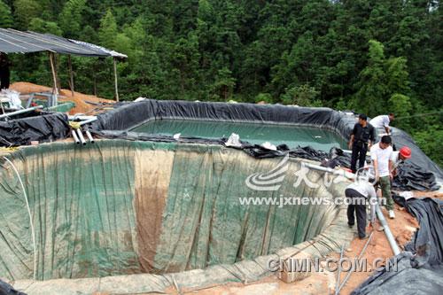 執(zhí)法人員對非法稀土礦點用炸藥進(jìn)行搗毀