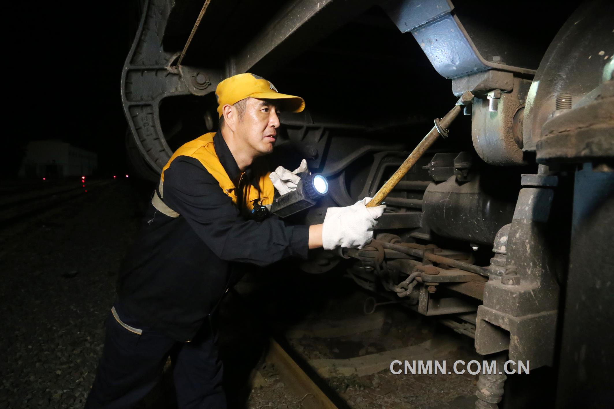 焦建智正在對待發(fā)礦石專列進行發(fā)車前的技術檢查。