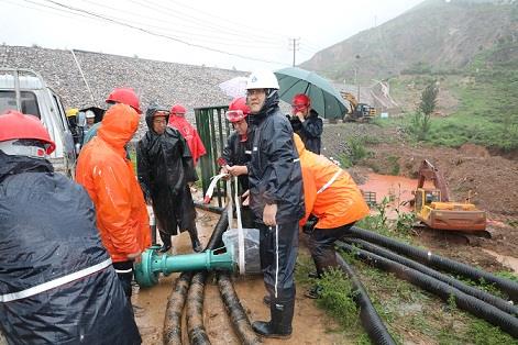 圖一為中州鋁業(yè)保障中心員工冒雨在現(xiàn)場搬運潛水泵設備，以應對未來幾天更加嚴峻的汛情。